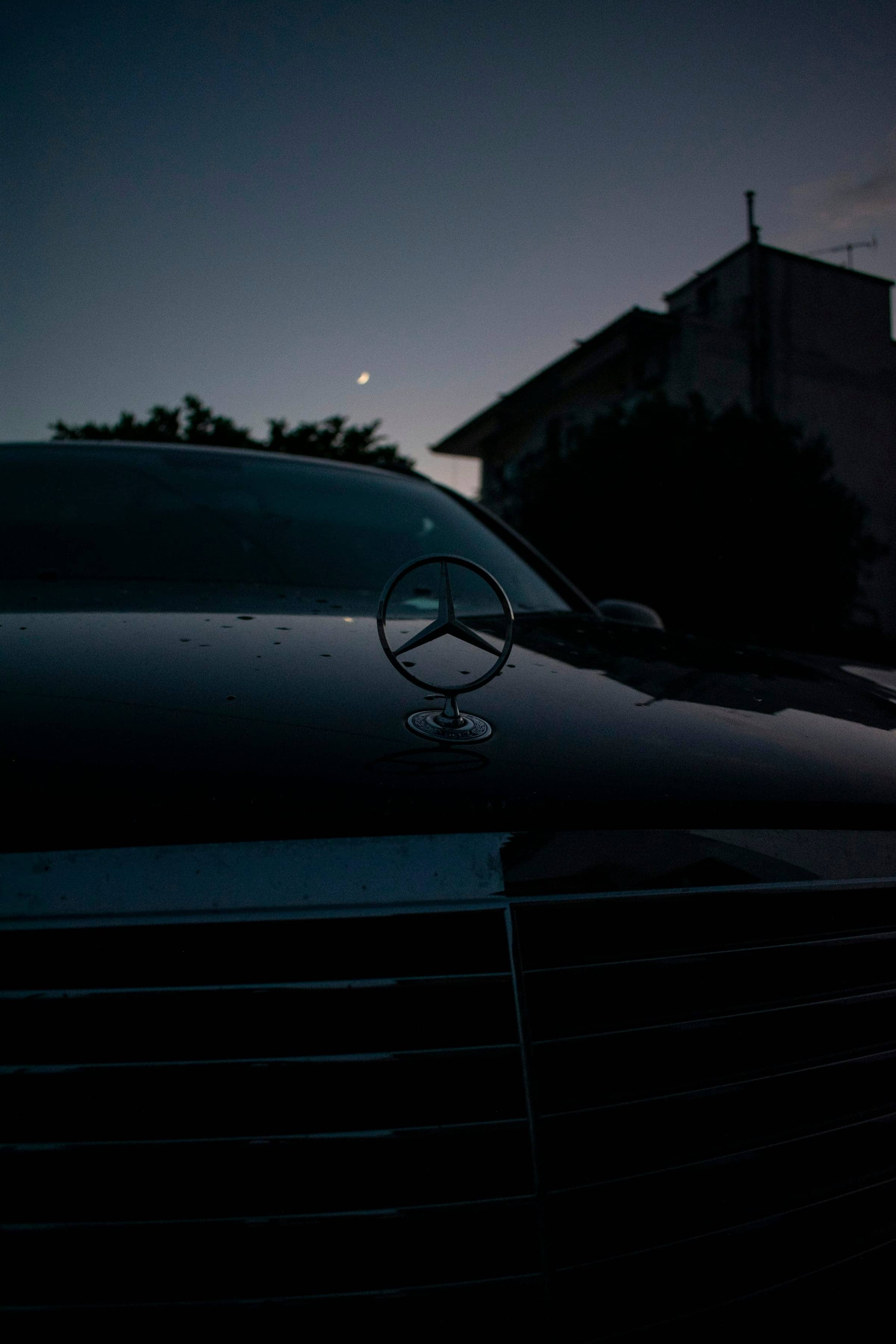 Zvezda Mercedes-Benz na črnem vozilu v mraku